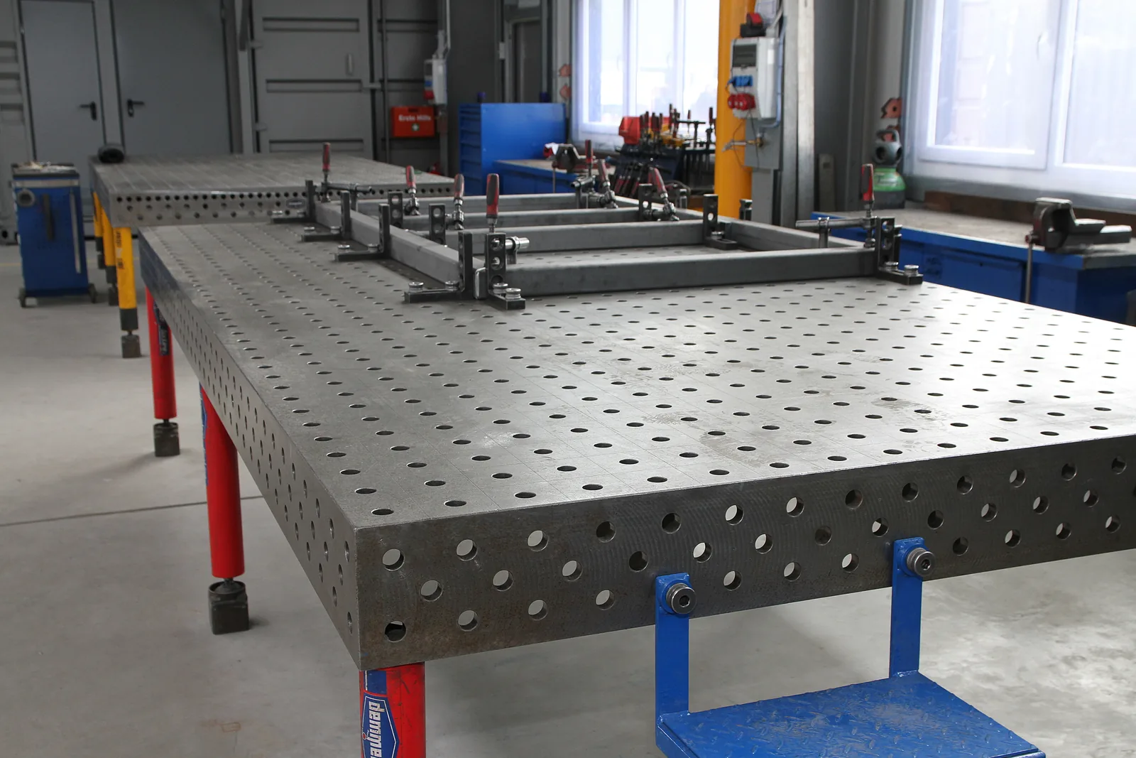 Duży stół spawalniczy z otworami w hali PIRON Metallbau GmbH
