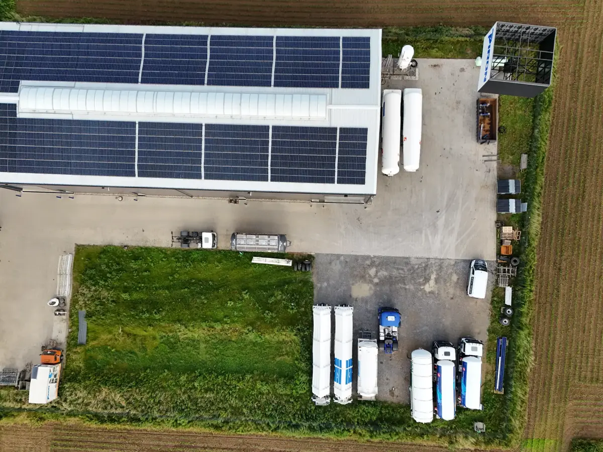 Luftbild des Geländes mit Halle, Photovoltaik auf dem Dach und Außenflächen
