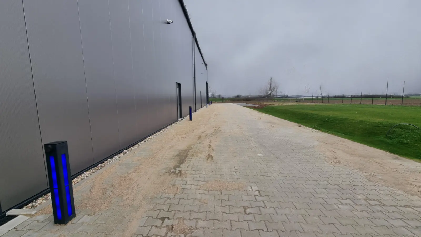 Gepflasterte Zufahrt entlang der Hallenwand