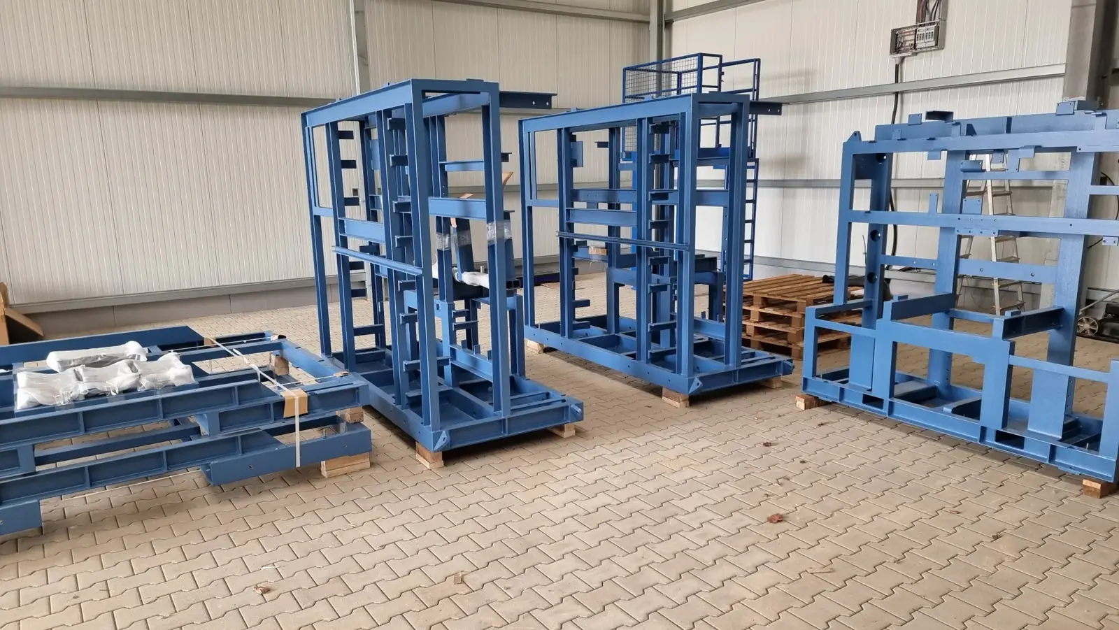 Blau lackierte Transportgestelle aus Stahl vor der Fertigungshalle