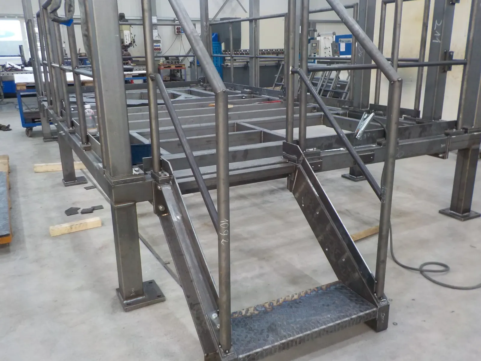 Stahlpodest mit Treppe und Geländer im Rohbau in der Fertigungshalle